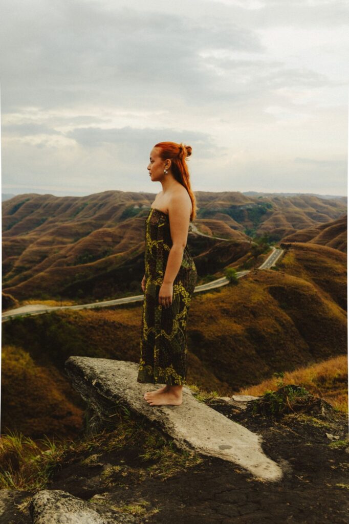 Portret van Jade in batikjurk met de heuvels van Sumba op de achtergrond