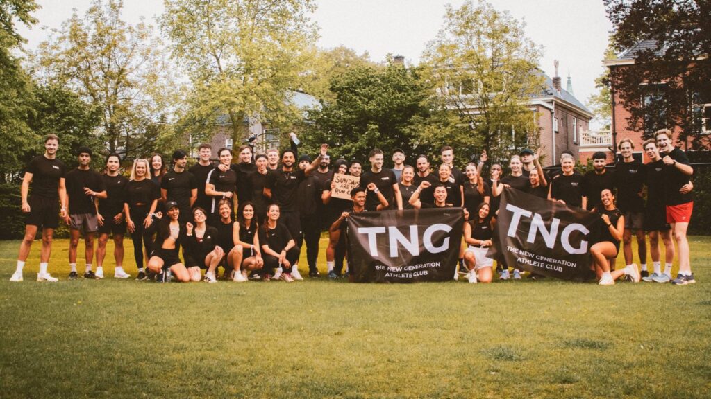 Groepsfoto van de hele TNG Running Club met twee vlaggen