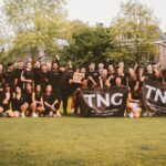 Groepsfoto van de hele TNG Running Club met twee vlaggen