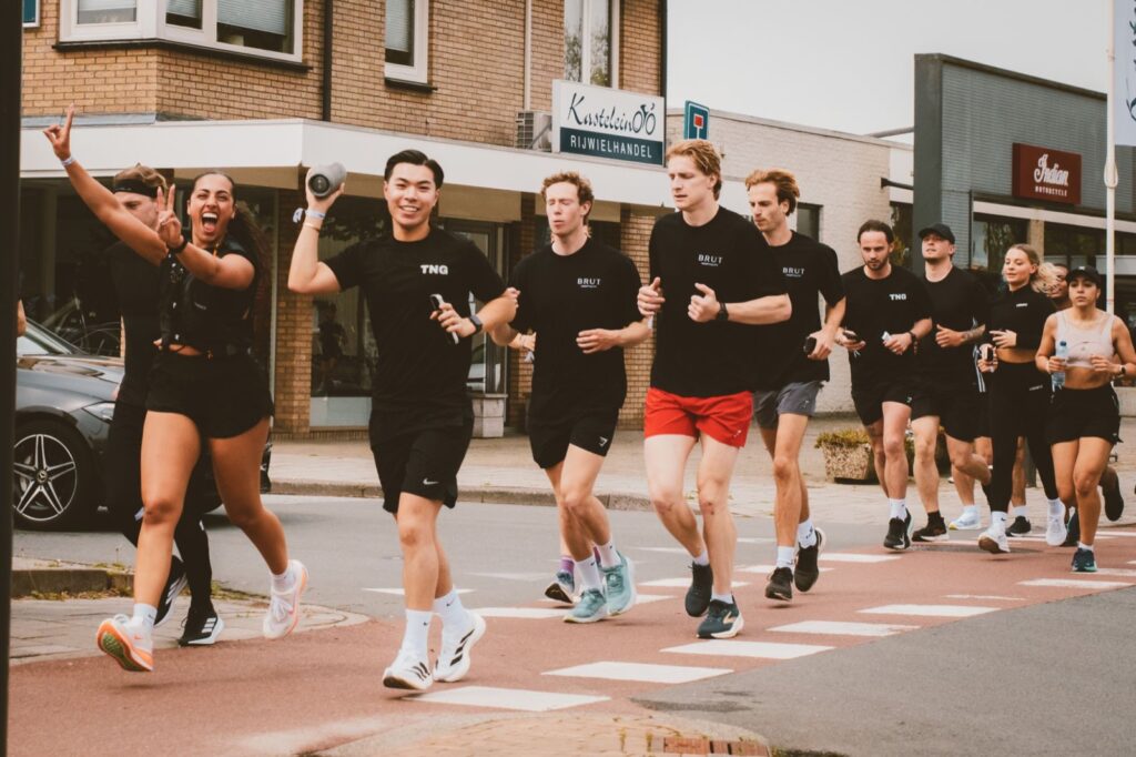 Loopgroep rent lachend door de straat