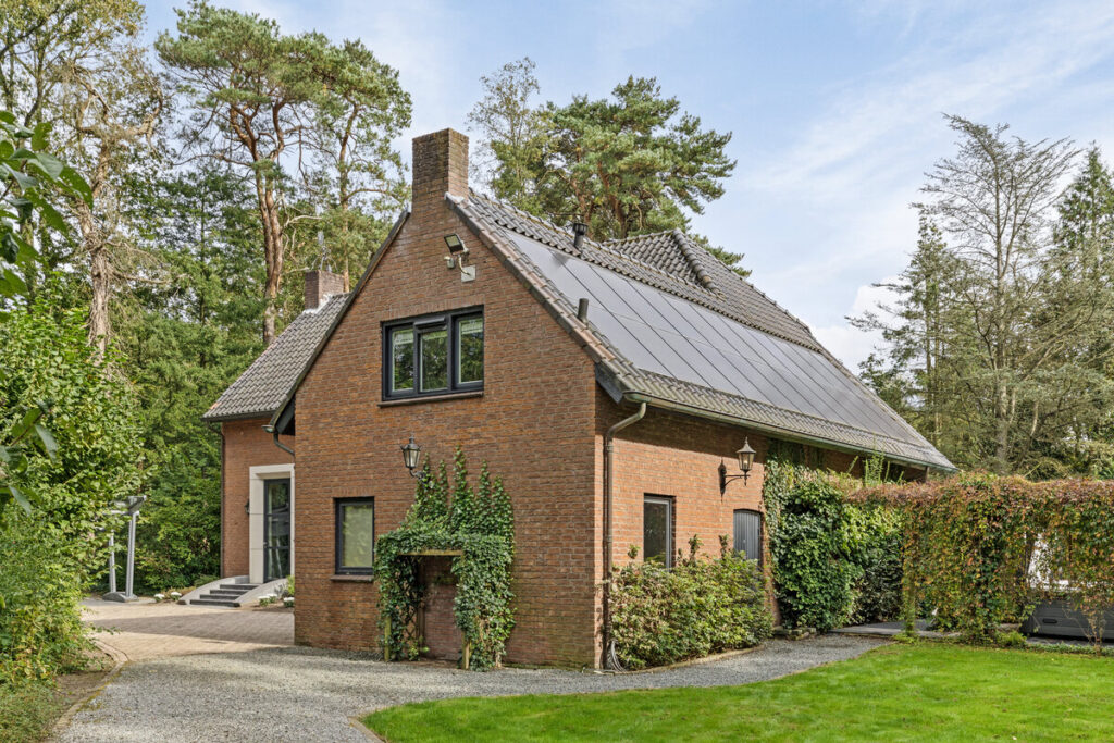 Zijgevel van een vrijstaande woning in het bos