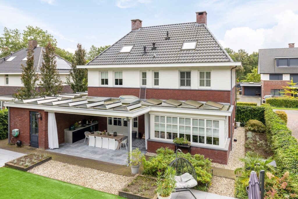 Achterzijde van een villa met overkapping en buitenkeuken