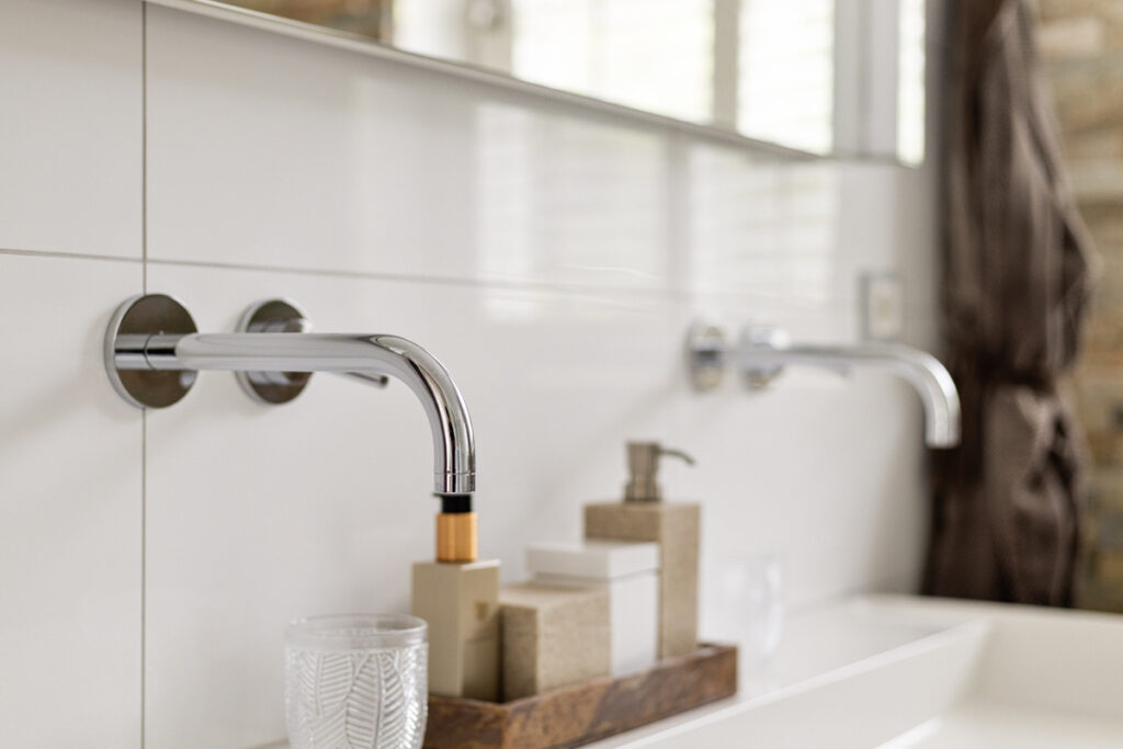 Detail van de kranen in een witte badkamer