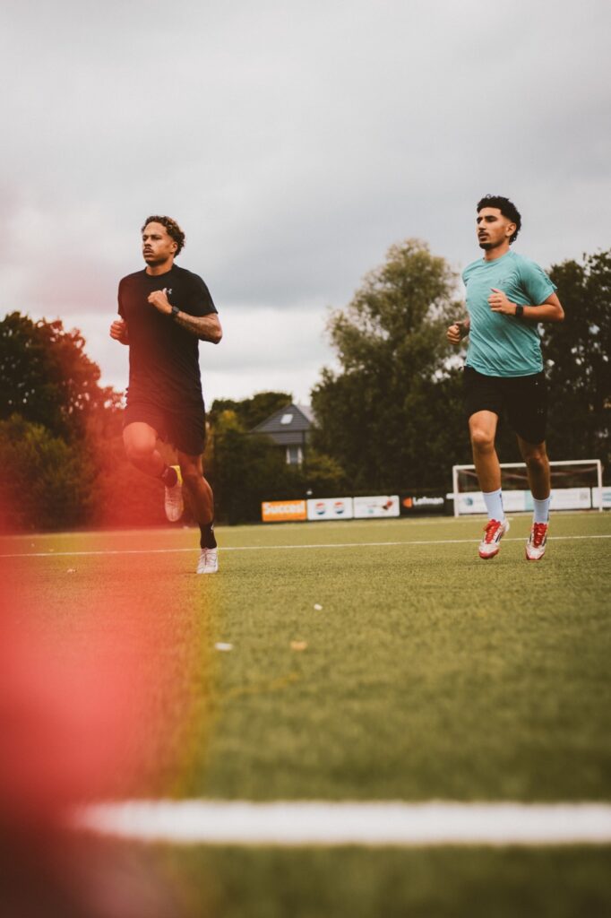 Twee spelers lopen in over het kunstgras
