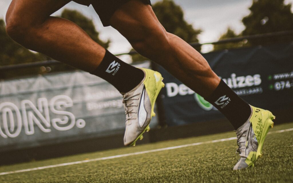 Close-up van een sprintende speler met gele schoenen