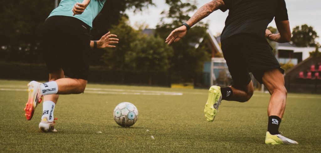 Twee spelers rennen achter de bal aan
